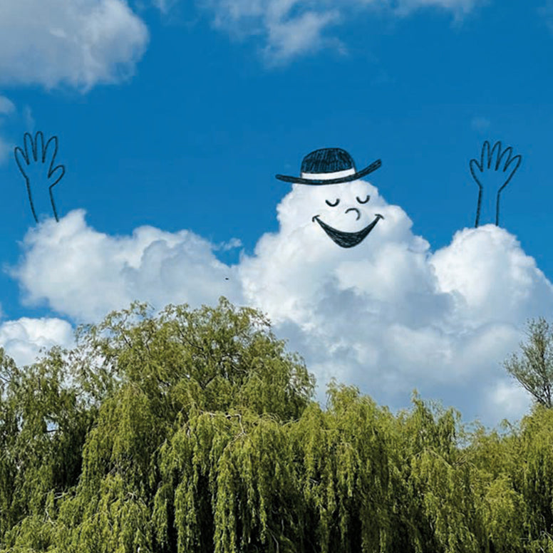 Large cloud-shaped character with a face and hat, surrounded by trees and blue sky.