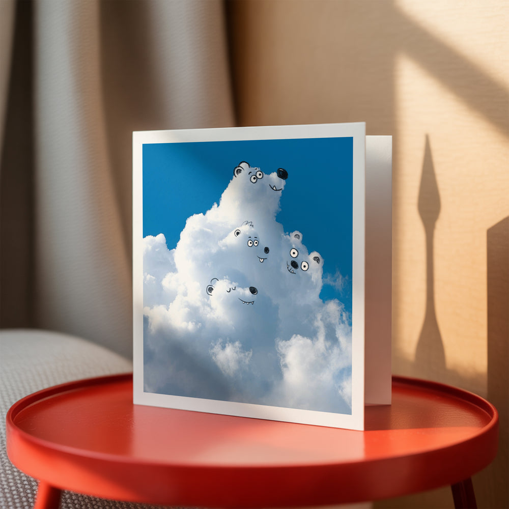 Card wit polar bears on a cloud against a blue sky, placed on a red table.