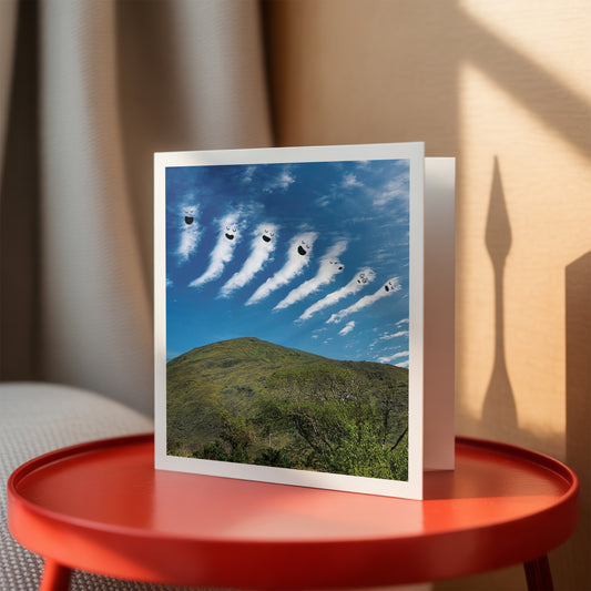 Greeting card with clouds over a mountain on a red table