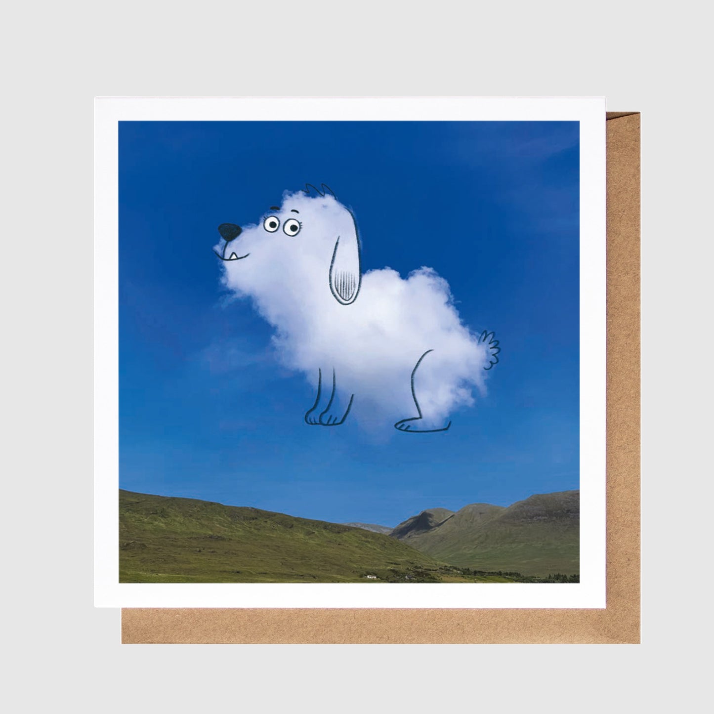 Card with a cloud-shaped dog illustration against a blue sky and green landscape