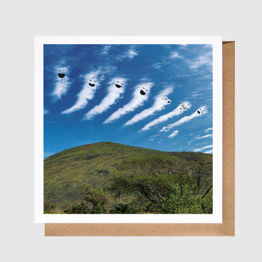 Greeting card with a scenic view of mountains and clouds against a blue sky.