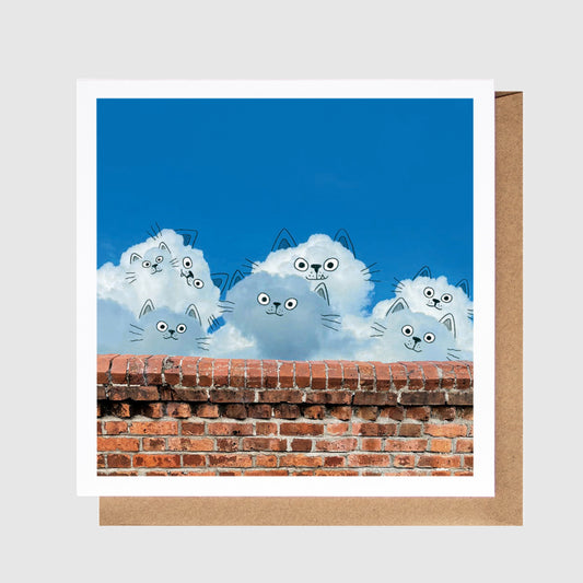 Card with cartoon cats on a blue sky background and brick wall at the bottom