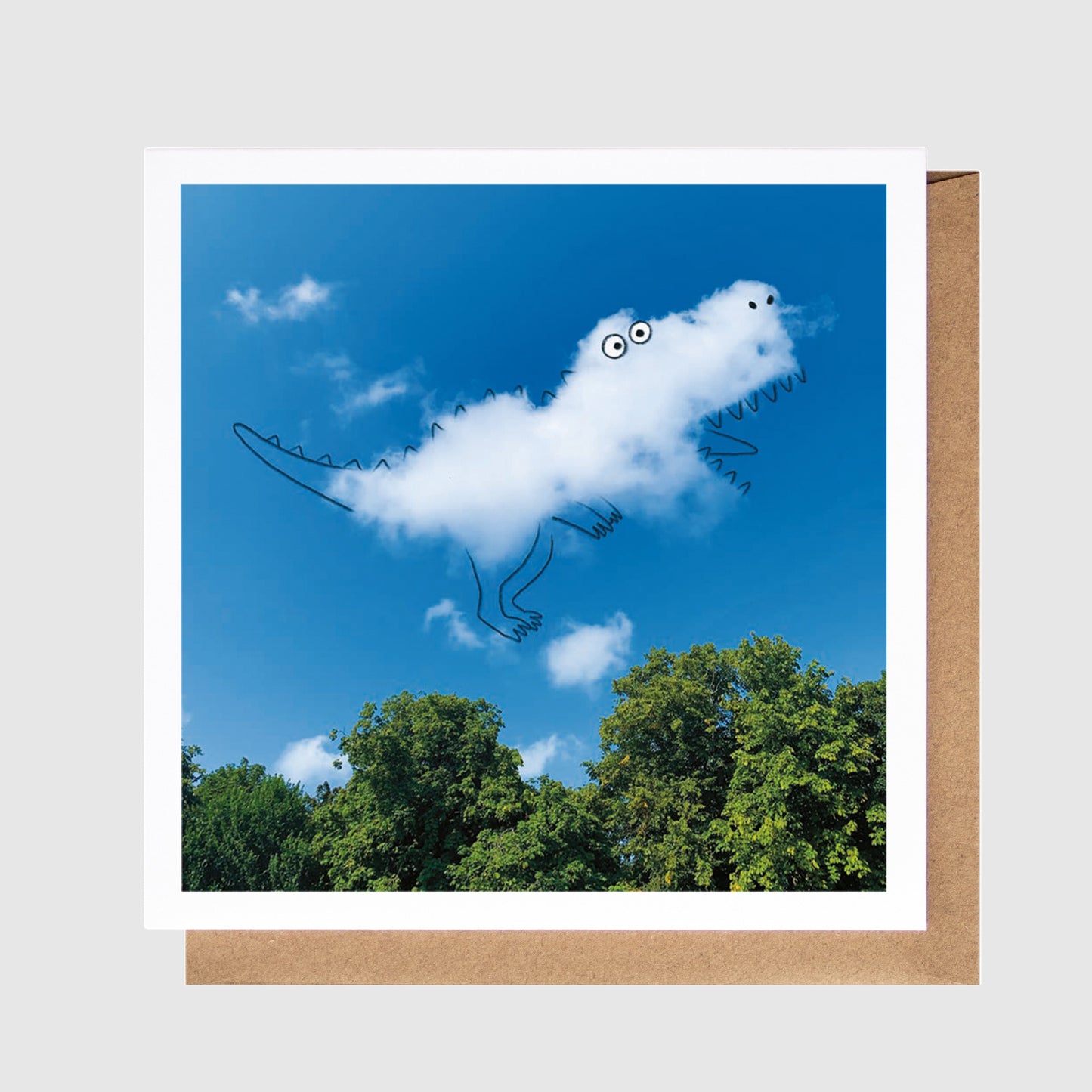 Cloud shaped like a lizard with googly eyes against a blue sky with trees below
