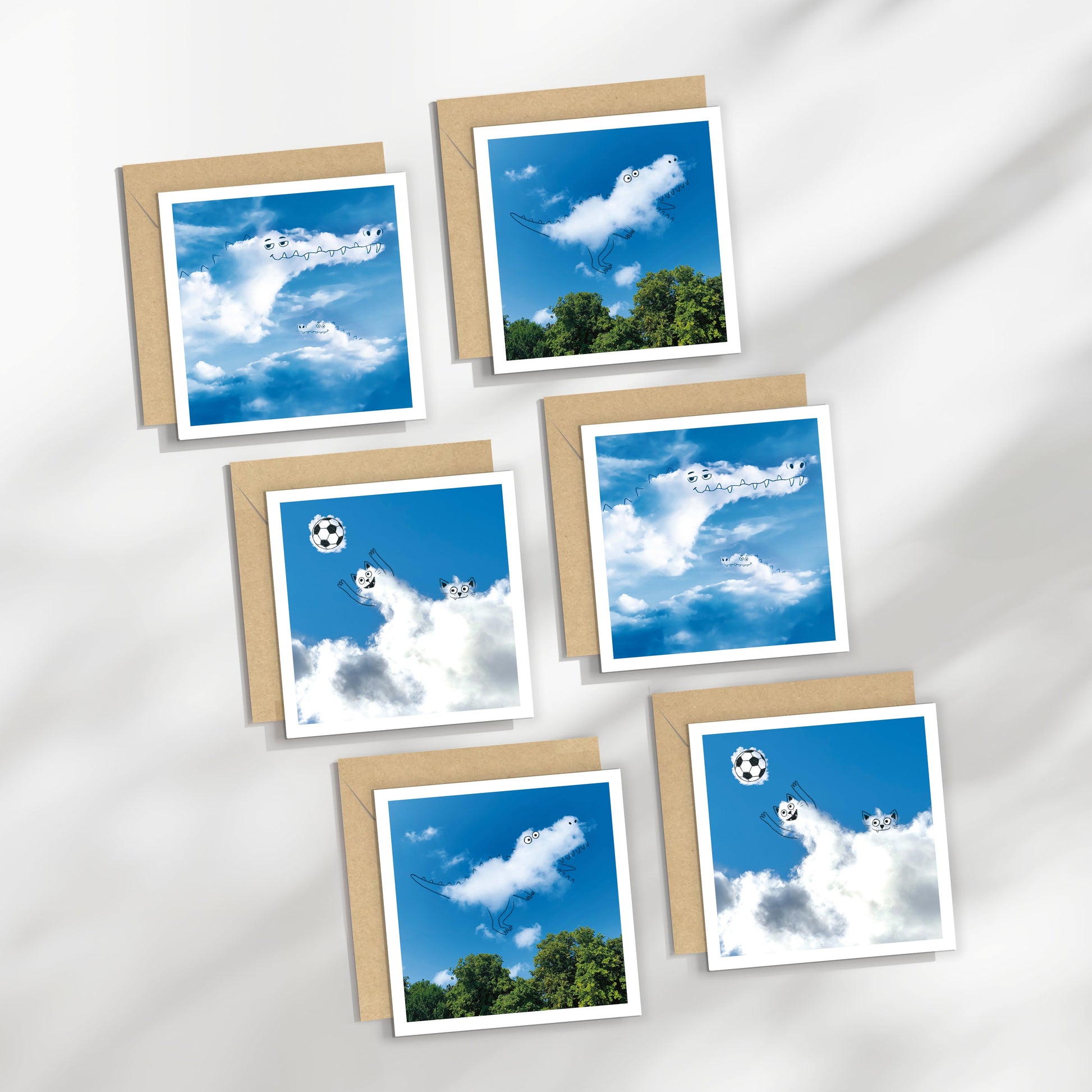 Set of greeting cards with blue sky and cloud designs on a white fabric background