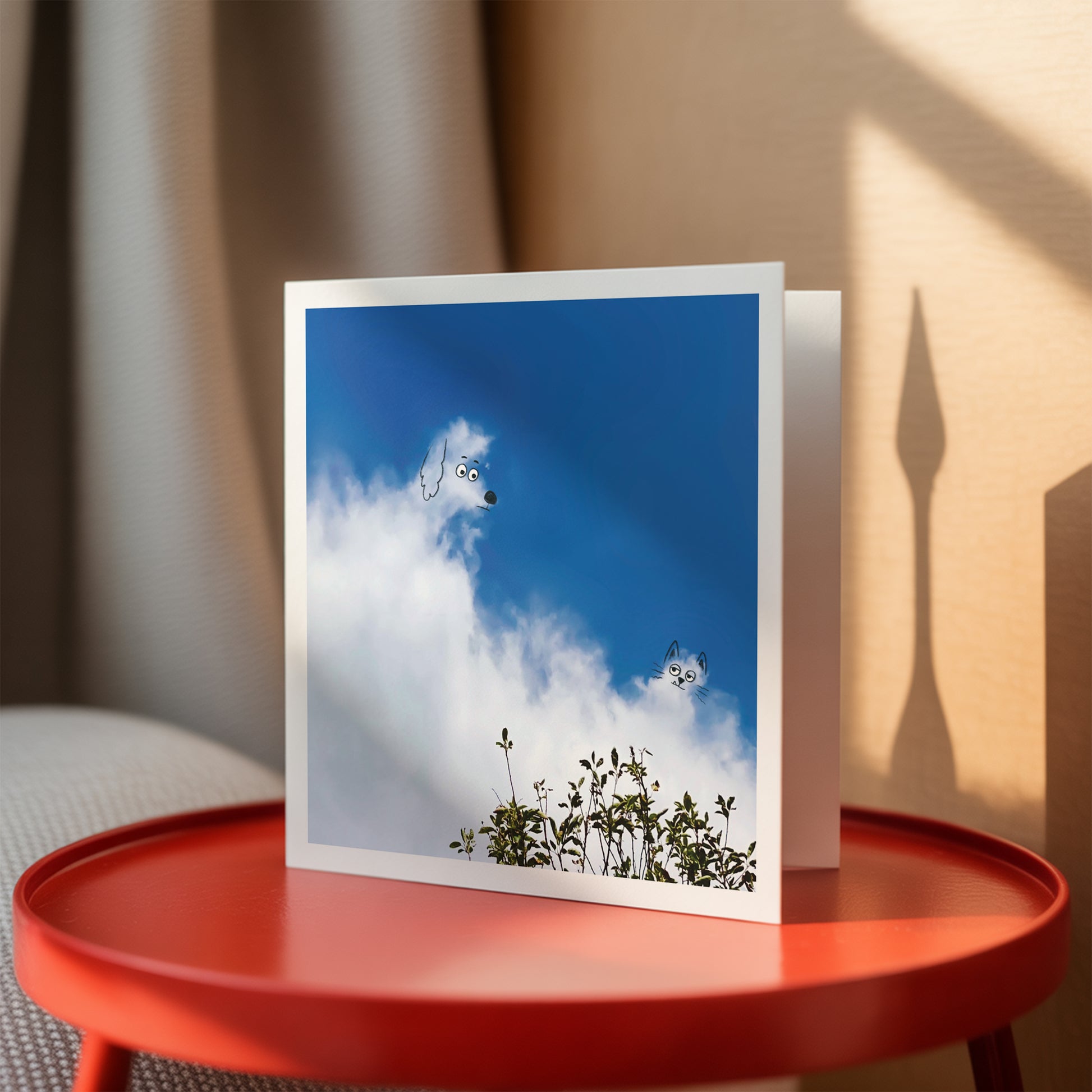 Greeting card with a blue sky and cloud design on a red table